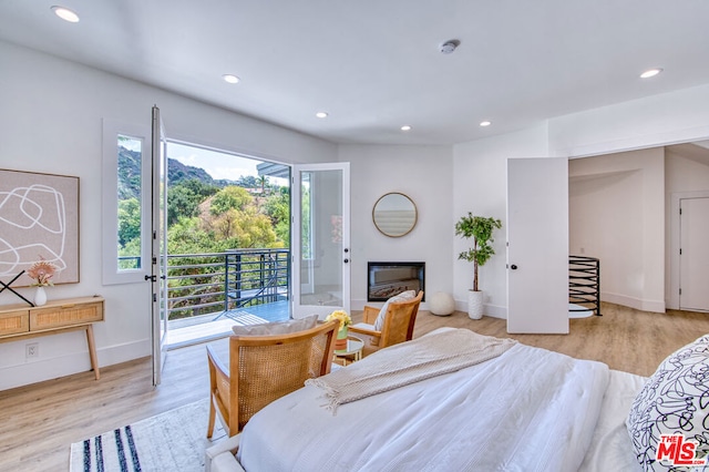 bedroom with access to outside and light wood-type flooring