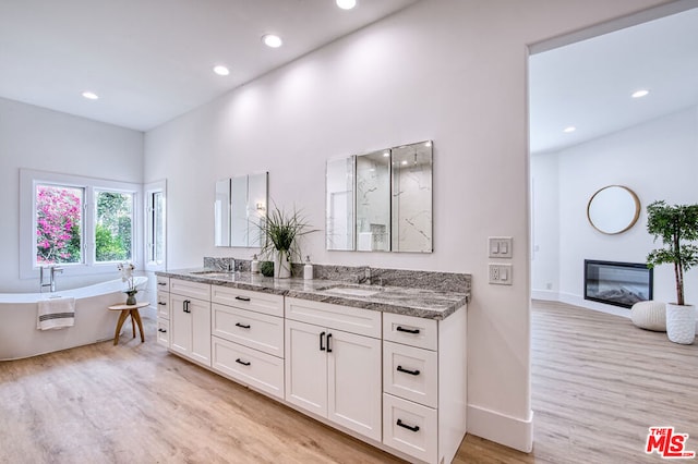 bathroom featuring hardwood / wood-style flooring, vanity, and a tub