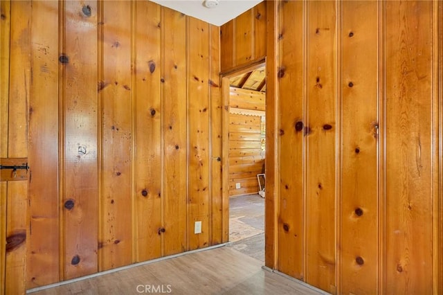 hall featuring wooden walls and light hardwood / wood-style floors