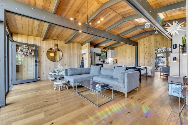 living room with wood ceiling, light hardwood / wood-style flooring, vaulted ceiling with skylight, and wood walls