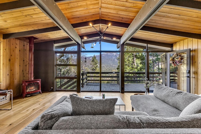 sunroom featuring wood ceiling, lofted ceiling with beams, a chandelier, and a wood stove