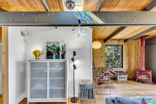 miscellaneous room with wood walls, a wood stove, hardwood / wood-style flooring, wood ceiling, and beam ceiling