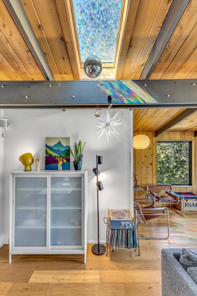 interior space with wood-type flooring, wooden ceiling, beam ceiling, and a skylight