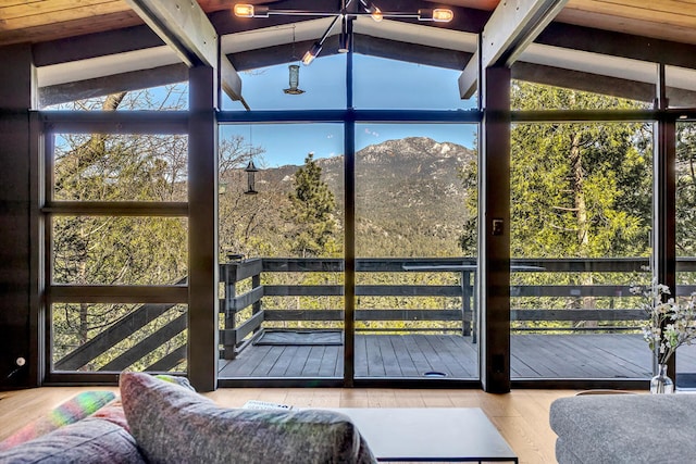 sunroom / solarium featuring lofted ceiling with beams and a mountain view