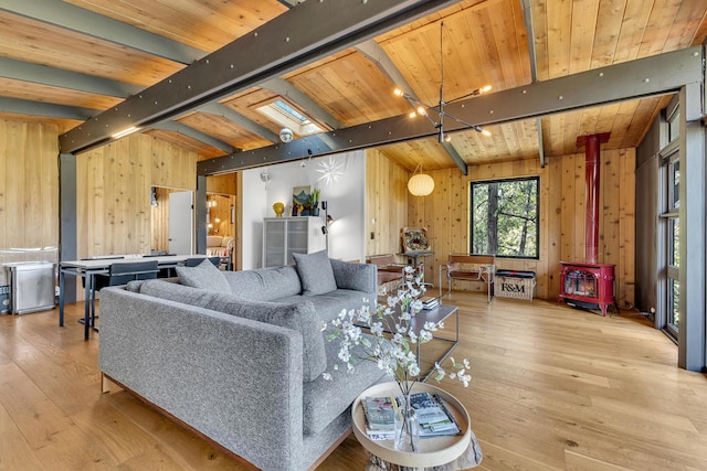 living room with wood ceiling, light wood-type flooring, wooden walls, and a wood stove