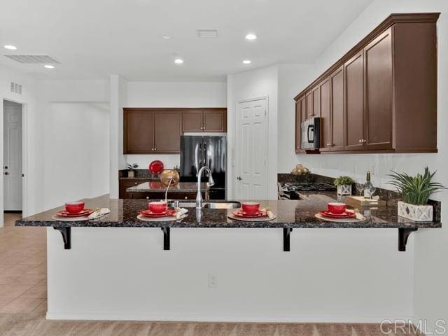 kitchen featuring sink, black appliances, and a kitchen bar