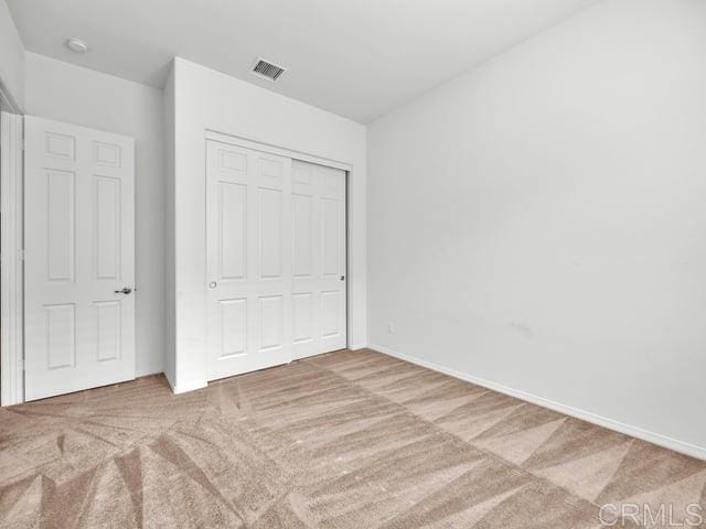 unfurnished bedroom with carpet and a closet