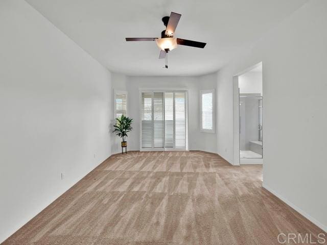 empty room featuring light colored carpet and ceiling fan