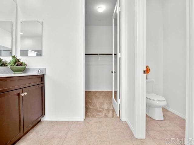 bathroom with tile patterned flooring, vanity, and toilet