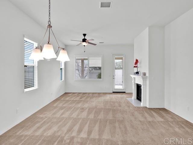 unfurnished living room featuring light colored carpet and ceiling fan