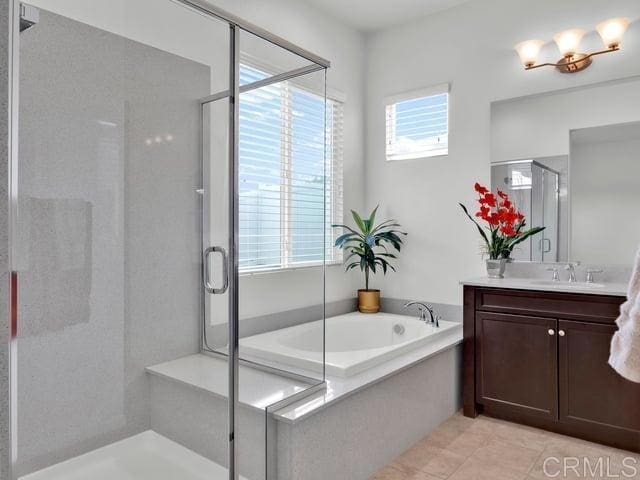 bathroom with vanity, plus walk in shower, and tile patterned flooring