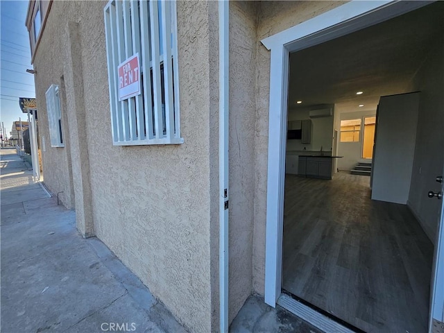 view of exterior entry featuring sink and a wall mounted AC