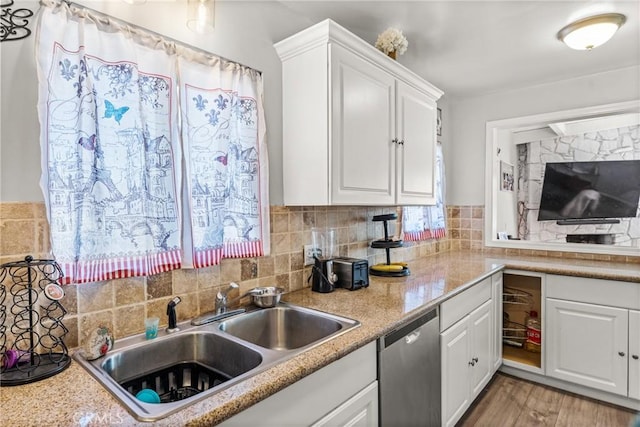 kitchen with white cabinetry, dishwasher, sink, decorative backsplash, and light hardwood / wood-style flooring