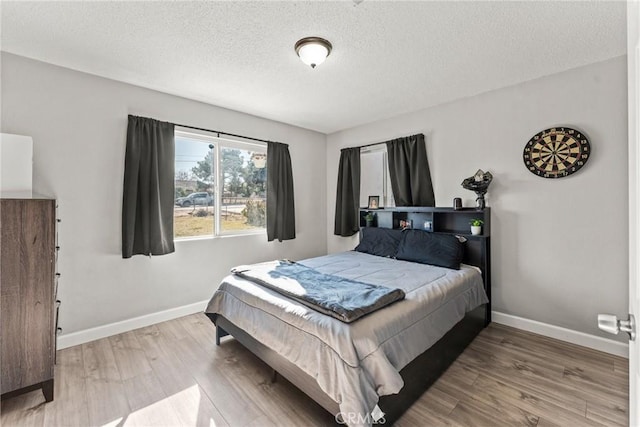 bedroom featuring wood-type flooring and a textured ceiling