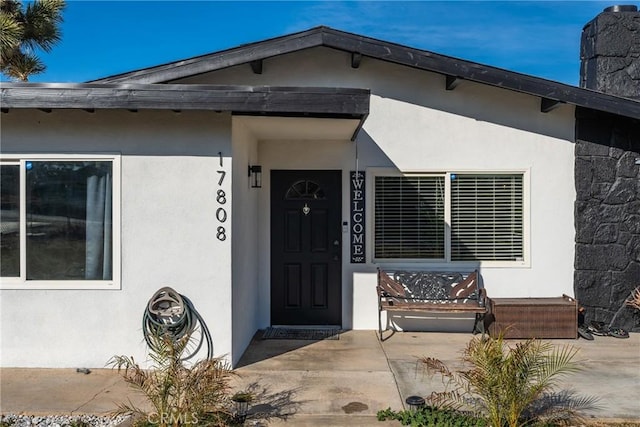 view of exterior entry with a patio