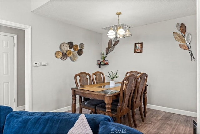 dining area featuring hardwood / wood-style floors and a notable chandelier