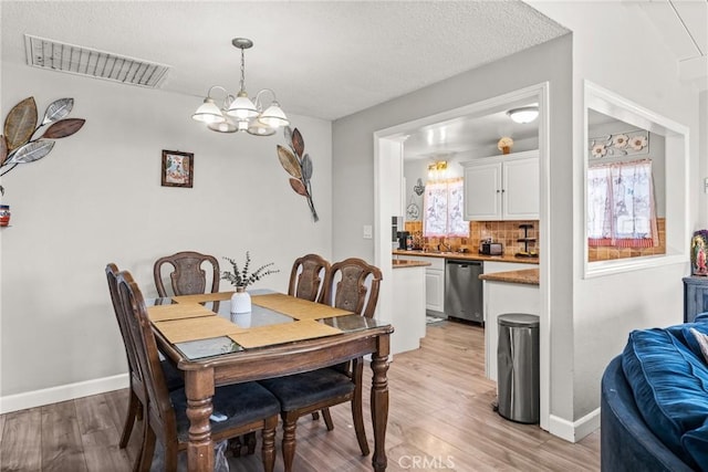 dining space featuring an inviting chandelier and light hardwood / wood-style floors