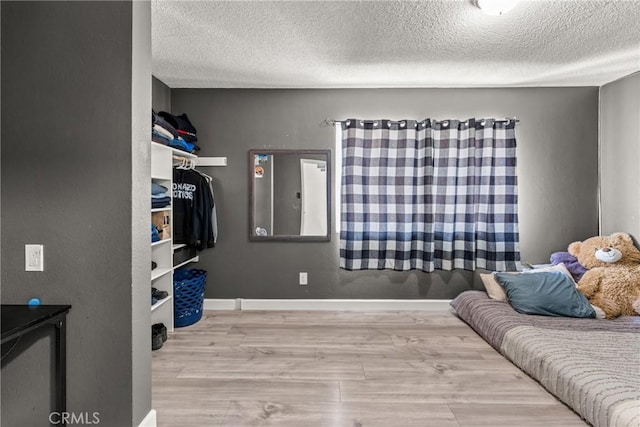 bedroom featuring a textured ceiling and light wood-type flooring