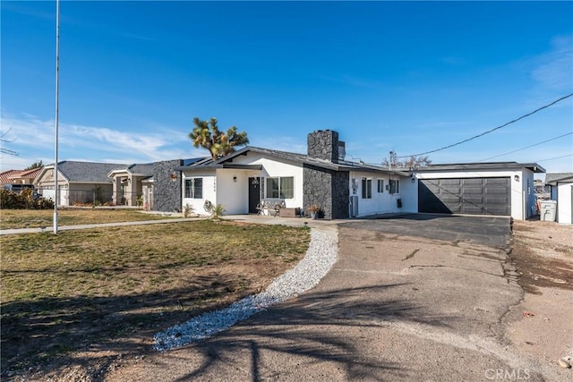 ranch-style house featuring a garage and a front yard