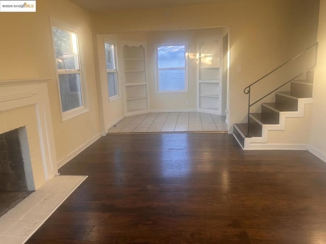 foyer entrance featuring a fireplace and dark hardwood / wood-style flooring