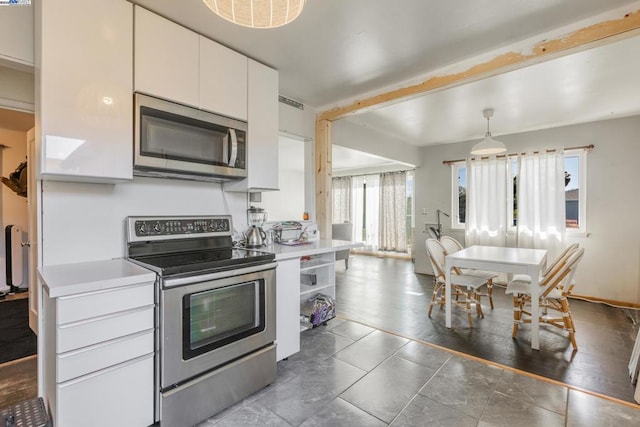 kitchen with decorative light fixtures, stainless steel appliances, and white cabinets