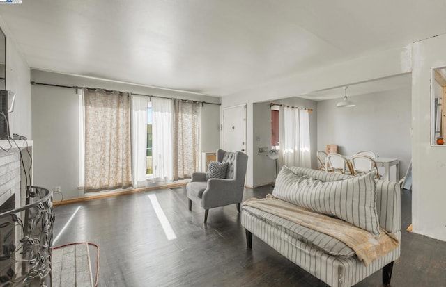 bedroom with a brick fireplace and dark hardwood / wood-style flooring