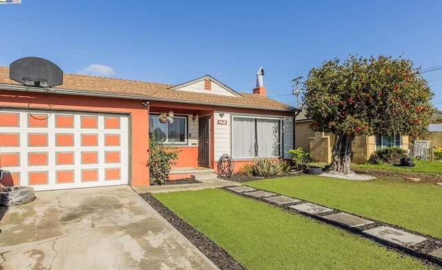 view of front of home with a garage and a front lawn