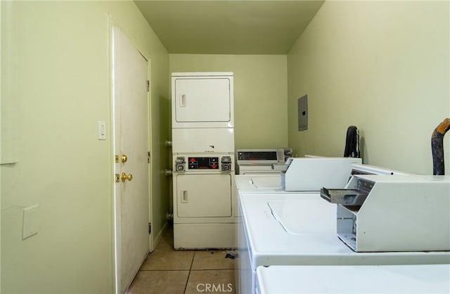 laundry room with stacked washer / dryer, light tile patterned floors, and electric panel