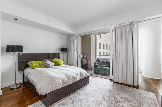 bedroom featuring access to exterior and dark wood-type flooring