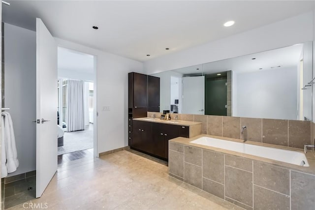 bathroom featuring vanity and a relaxing tiled tub