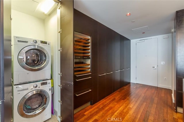 laundry room with stacked washer and dryer and hardwood / wood-style floors