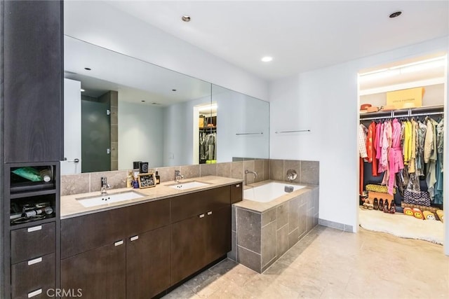 bathroom featuring vanity and tiled tub