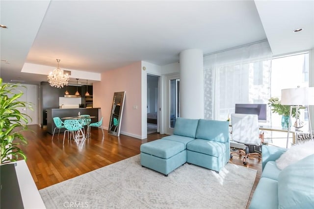 living room with an inviting chandelier, expansive windows, and hardwood / wood-style floors