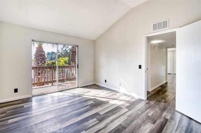 empty room with dark wood-type flooring and high vaulted ceiling