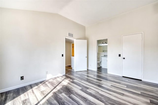 unfurnished bedroom with lofted ceiling, ensuite bathroom, and light hardwood / wood-style flooring