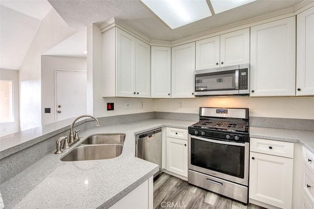 25246 San Michele, Laguna Niguel, CA 92677 - kitchen with light stone counters, light wood-style flooring, a sink, white cabinets, and appliances with stainless steel finishes
