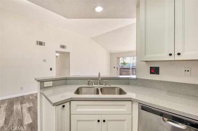 kitchen featuring sink, light hardwood / wood-style flooring, vaulted ceiling, stainless steel dishwasher, and kitchen peninsula