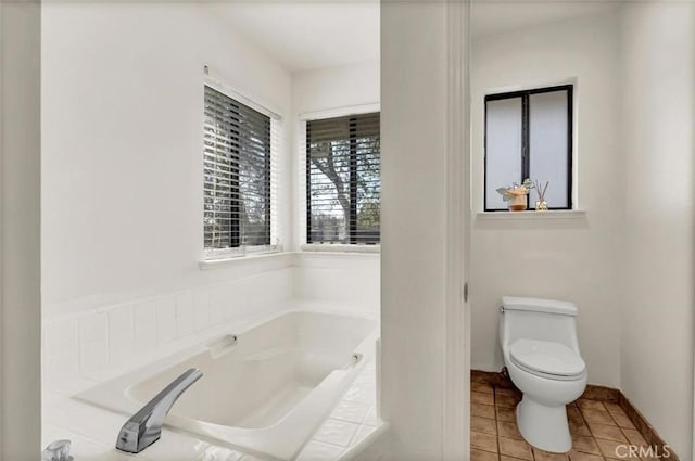 bathroom featuring toilet, tile patterned flooring, and tiled tub