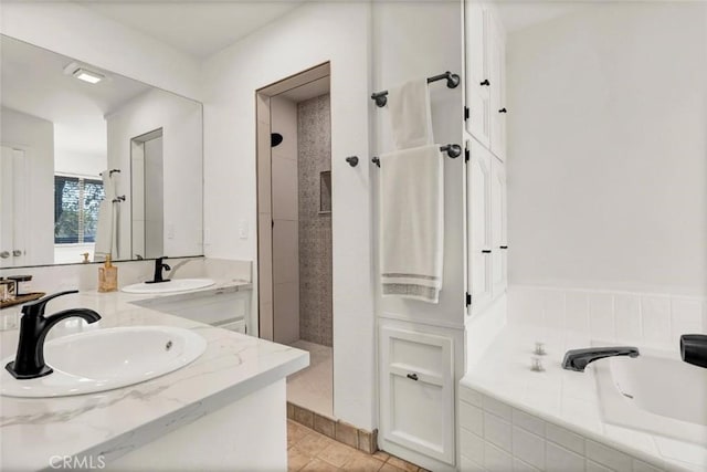 bathroom with tile patterned flooring, vanity, and plus walk in shower