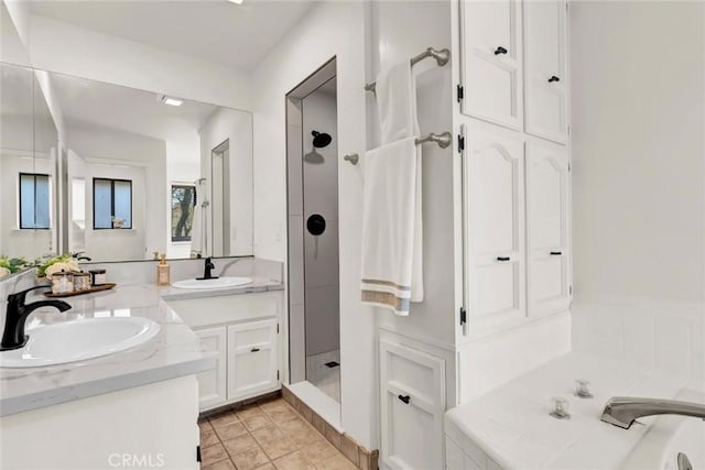 bathroom with tile patterned flooring, vanity, and walk in shower