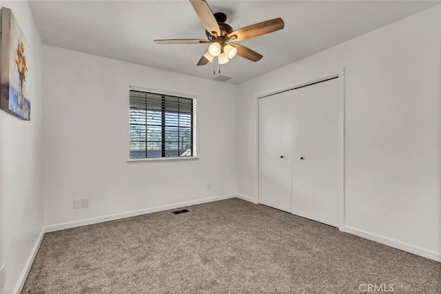 unfurnished bedroom featuring light colored carpet, ceiling fan, and a closet