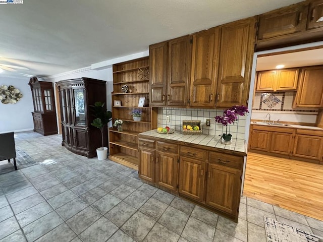 kitchen featuring tasteful backsplash, sink, tile countertops, and light tile patterned flooring