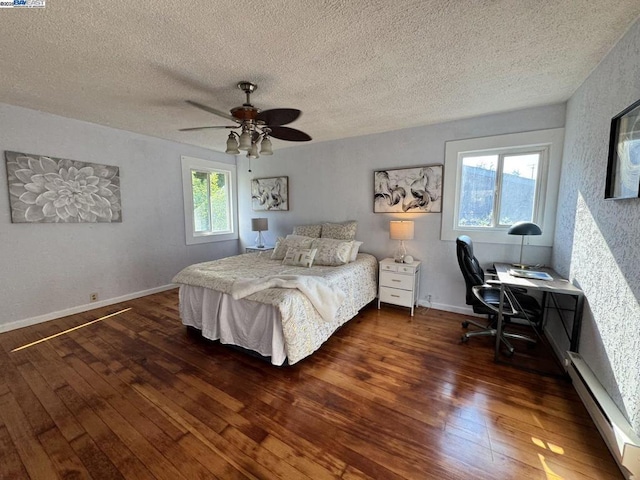 bedroom featuring dark wood-type flooring, ceiling fan, a textured ceiling, and a baseboard heating unit