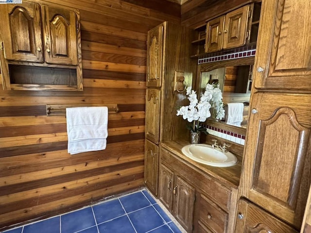 bathroom with vanity, tile patterned floors, and wooden walls