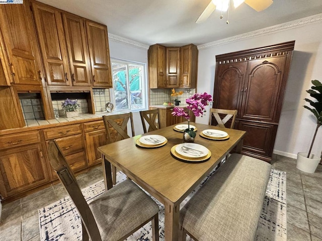 dining space with crown molding and ceiling fan