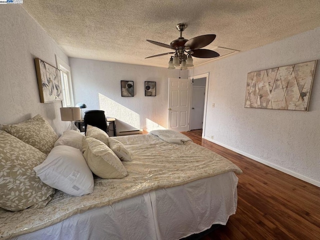 bedroom featuring ceiling fan, dark wood-type flooring, and a textured ceiling