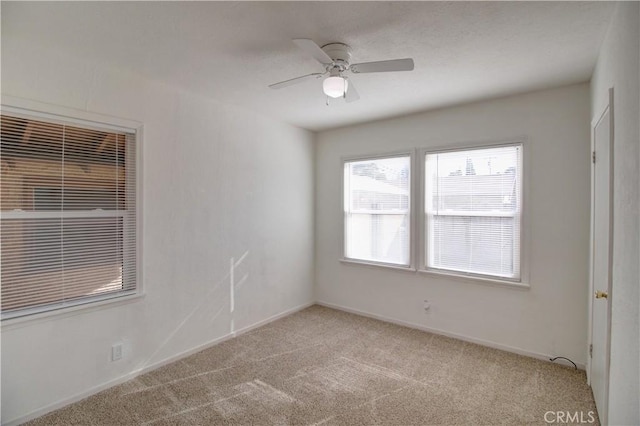 carpeted spare room with ceiling fan