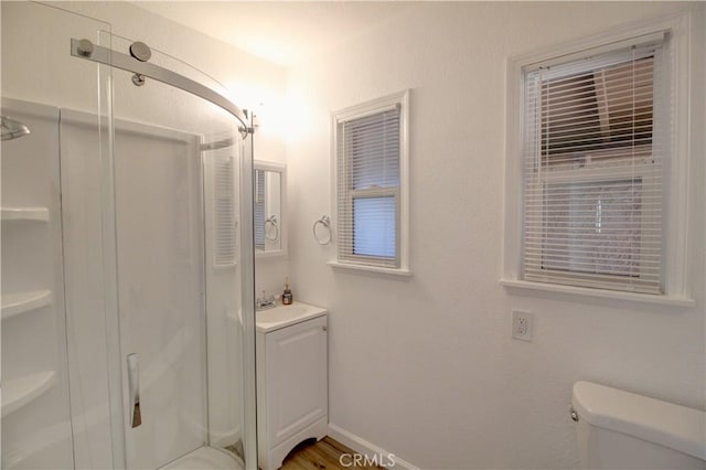 bathroom featuring walk in shower, vanity, and toilet