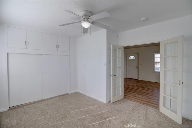 carpeted empty room with french doors and ceiling fan