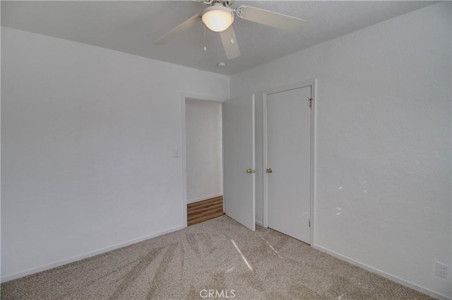 spare room featuring light colored carpet and ceiling fan